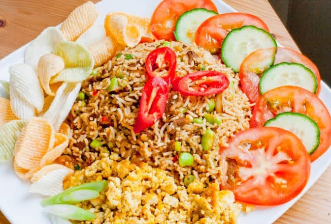Usaha nasi goreng pinggir jalan dengan gerobak dan perlengkapan jualan.